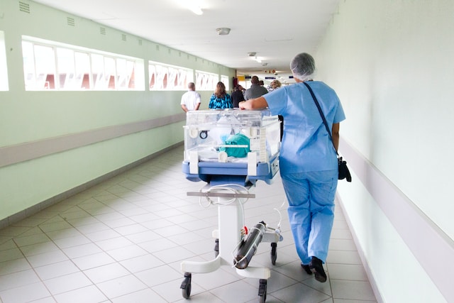 Hospital hallway with patients and doctors.