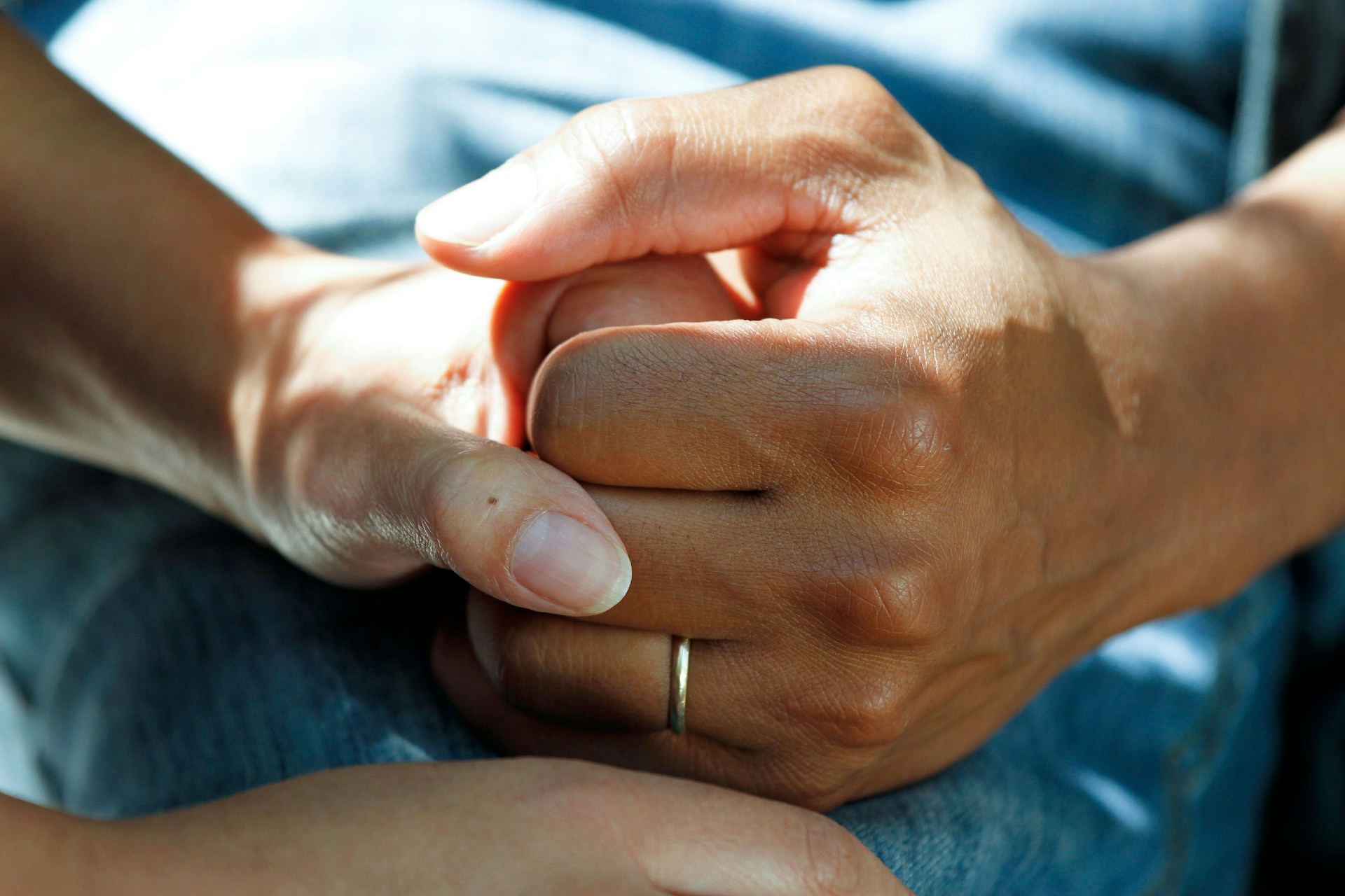 A caregiver holding hands of a patient, providing emotional support. 