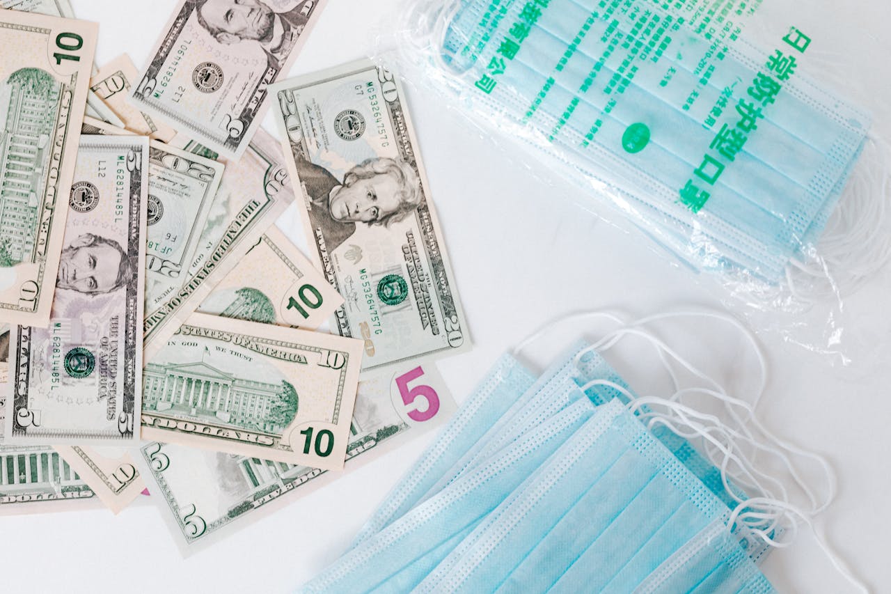 The image contains US dollar bills alongside medical masks.